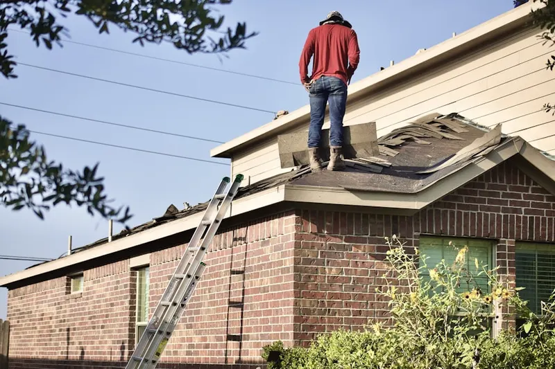Professional roofer working on a residential roof in West 4th Street